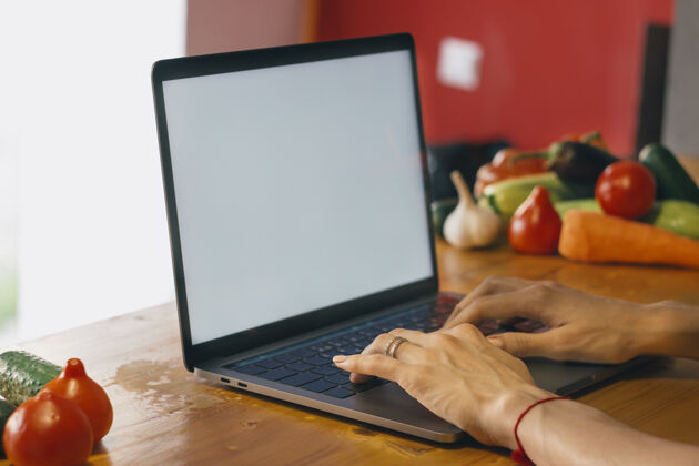 人厨房里一个拿着笔记本电脑的小女孩正在找食谱美丽电脑打字