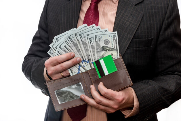 纸西装革履的男人拿着钱包 里面有美元钞票和信用卡钱人借方