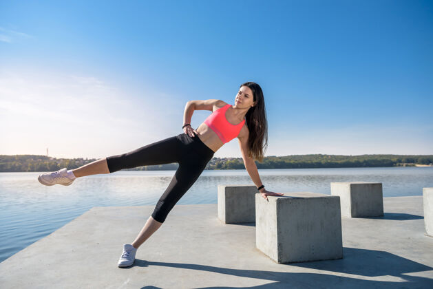 和平做俯卧撑的年轻女运动员白天在湖边做健身操的女孩活力俯卧撑健康