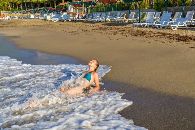 大海年轻女孩沐浴在地中海的波涛中休闲沙滩游泳