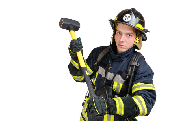 年轻人全身穿着制服 戴着消防员安全帽和防毒面具的年轻勇士挥舞着大锤穿制服戴安全帽