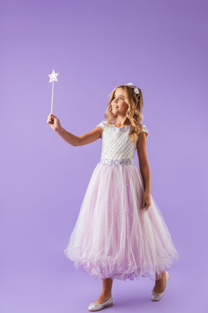 幻想一个微笑的漂亮女孩的全身肖像 穿着公主裙 隔着紫罗兰色的墙 手持魔杖愿望衣服童话