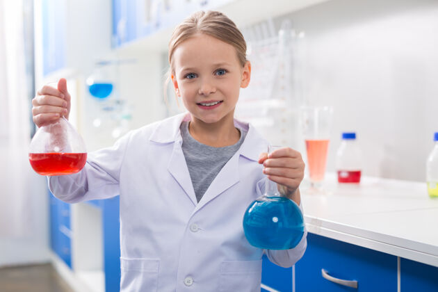 课堂最喜欢的科目积极可爱的好女孩拿着烧瓶看着你 同时对化学感兴趣年轻实验室室内