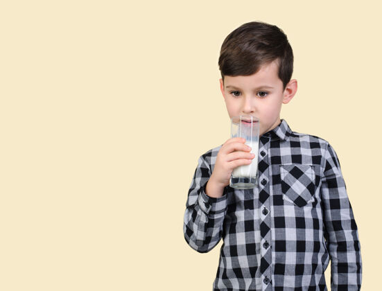 情绪穿灰色衬衫的男孩在浅色背景下喝牛奶牙齿的微笑童年肖像