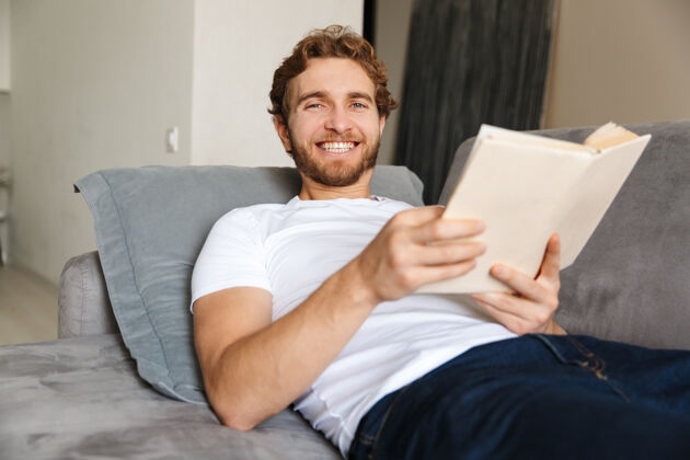 阅读一个留着胡子的帅哥坐在家里的沙发上看书知识室内成人