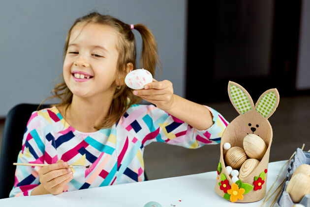 小女孩快乐的小女孩在家画画 用毛笔蛋画画孩子准备复活节 玩得开心 庆祝节日复活节快乐 diy特写可爱兔子