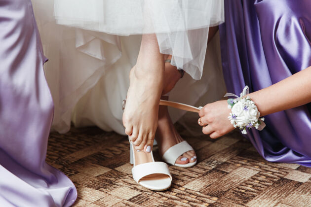 花新娘穿上白色的婚鞋女人身体仪式
