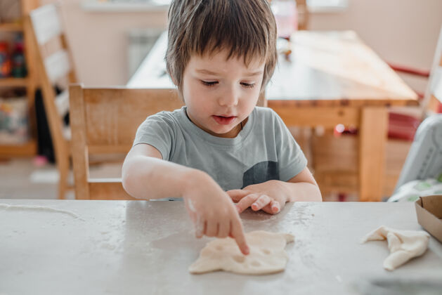 糕点可爱的小男孩在厨房做饼干面包别针童年