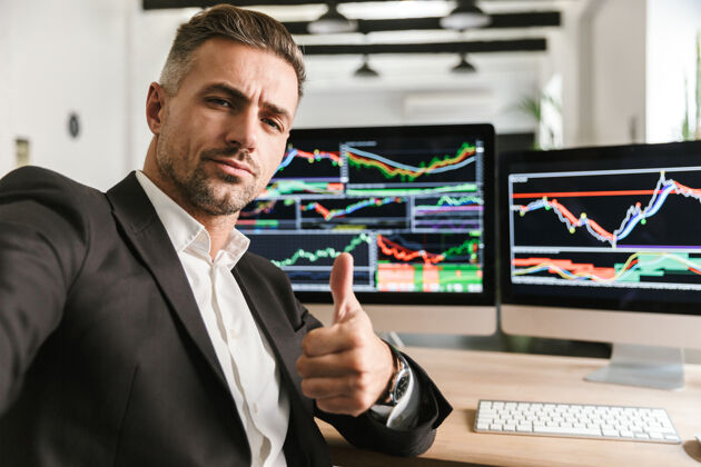数字一张30多岁的商务人士穿着西装在办公室里用电脑自拍的照片 屏幕上有图片和图表在线财务图形