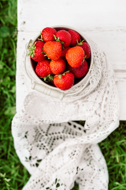 多收起垂直的草莓在桶里 夏天在村里 收获品种夜晚封闭