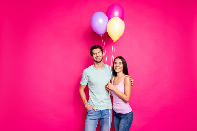 空气图为搞笑男女情侣手拿气球来到父母生日派对穿休闲装隔离粉色背景关系可爱丈夫