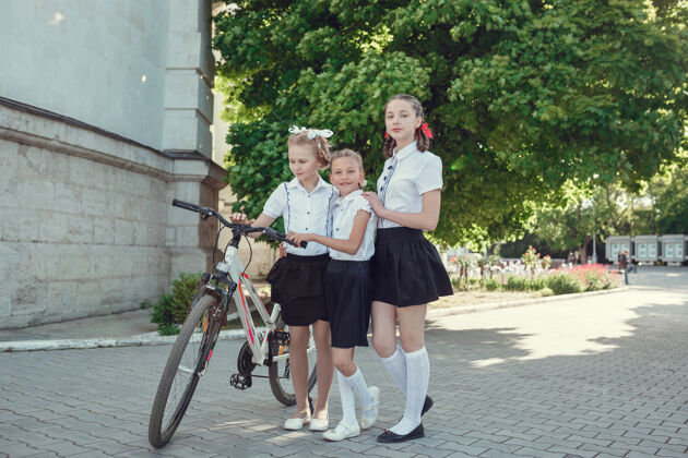 肖像快乐时尚的小朋友们在城市里玩自行车的写真夏季朋友自行车