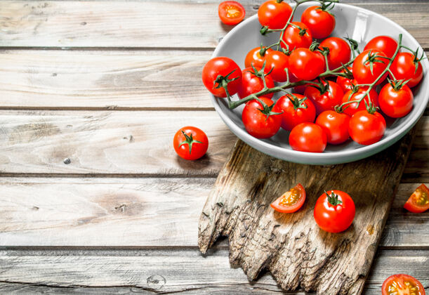 植物把西红柿放在盘子里 放在砧板上 放在木桌上生动木材切割