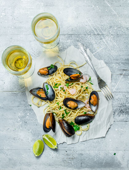 面条地中海意大利面木桌上有海鲜 蛤蜊和白葡萄酒香草美味海鲜