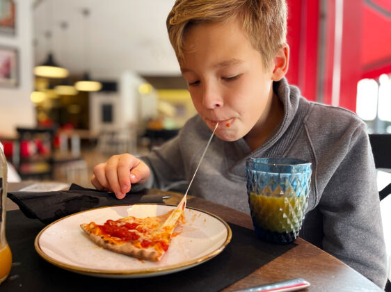 比萨比萨里的融化的奶酪是最美味的东西男孩在比萨店享用午餐快餐意大利饥饿