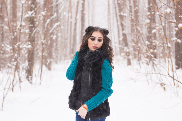 模型美丽的年轻女子行走在冬雪的大自然中成人女性圣诞节