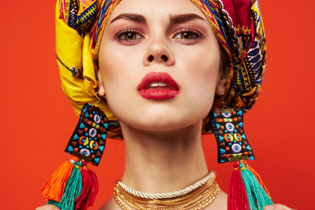 头女人戴着五彩斑斓的头巾装饰着迷人的民族红墙快乐嘴唇女性
