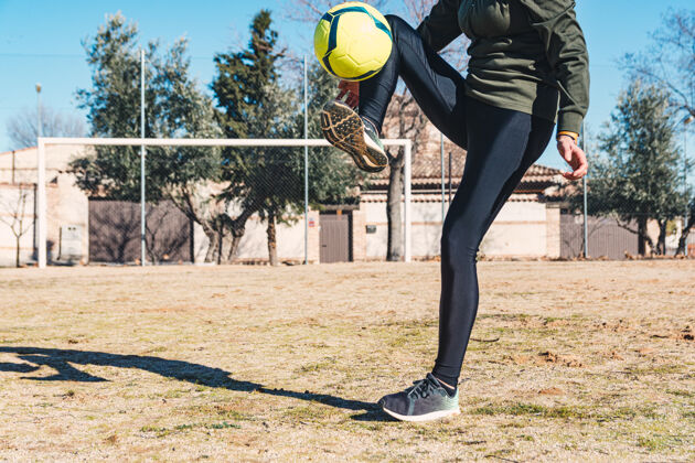 足球和她一起控制和踢球的女人英尺.地面足球现场女性足球概念黄色训练踢
