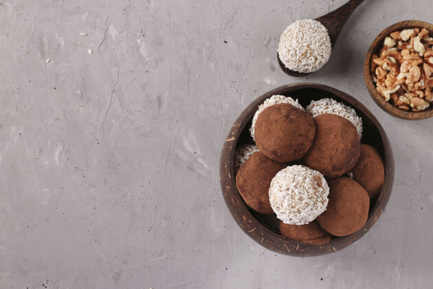 素食主义者能量球的坚果和燕麦与椰子片和可可粉椰子碗在灰色的表面 水平格式 俯视图 复制空间糖果古美味