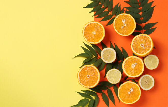 烹饪柠檬和橘子的一半与绿色的叶子在明亮的黄色橙色表面与文本空间组成 平放条纹叶子维生素