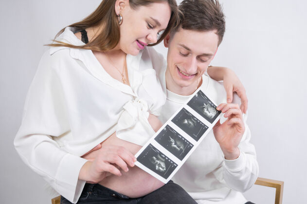 爸爸年轻夫妇在看未出生婴儿的超声波检查男人怀孕妈妈