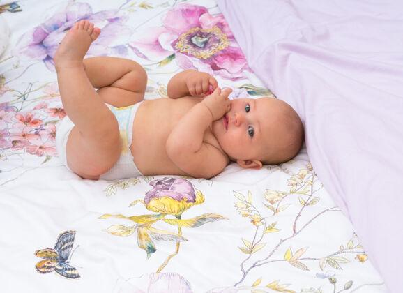 婴儿床快乐的小女婴 换了尿布 躺在床上踢腿兴趣肖像女儿