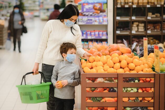 公眾真實(shí)的母子倆戴著醫(yī)用口罩在超市買食品的照片手推車孩子