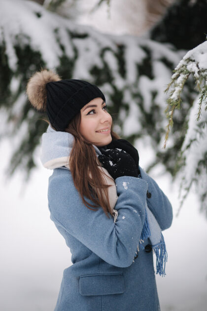 家庭冬天的雪天 穿着蓝色外套的漂亮女人在树林里散步可爱户外童年