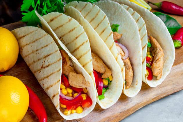 蔬菜拉丁美洲玉米饼 鸡肉和玉米放在木板上 特写一餐墨西哥玉米卷豆类
