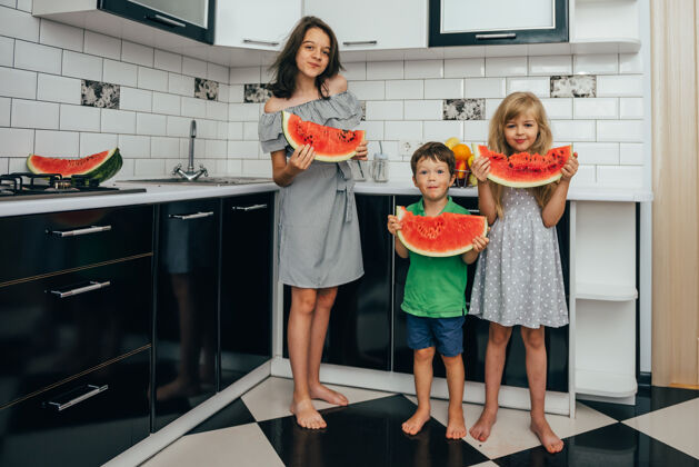 水果三个快乐微笑的孩子在厨房吃西瓜新鲜西瓜健康