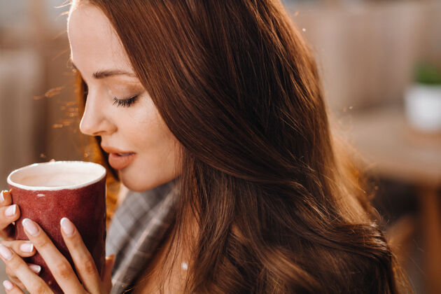 可爱一个女孩在咖啡店喝咖啡 一个漂亮的女孩的头发黑发杯子满足