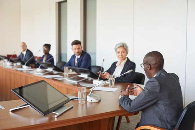 计算机商务会议期间 一群商务人士坐在会议桌旁聆听演讲者的演讲公司业务商务人士自信
