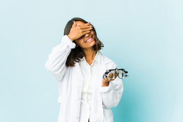 眼镜师年轻的眼科医生拉丁女人用手捂住眼睛 微笑着等待惊喜拉丁语表情微笑