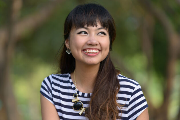 灵感年轻美丽的亚洲女子在公园户外放松的写真砰发型和平