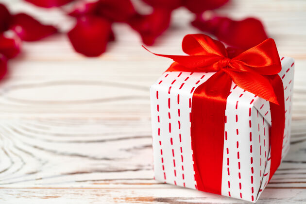礼物情人节礼物和木桌上的玫瑰情人节花瓣礼物