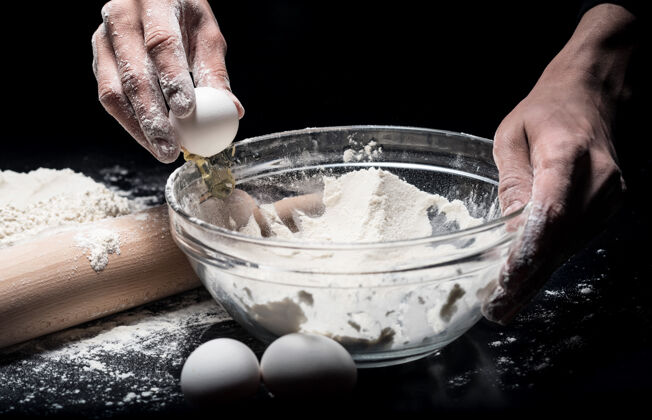 风味烹饪进程关闭在餐馆工作的时候 人们用手做面团 用鸡蛋和面粉手对比装饰