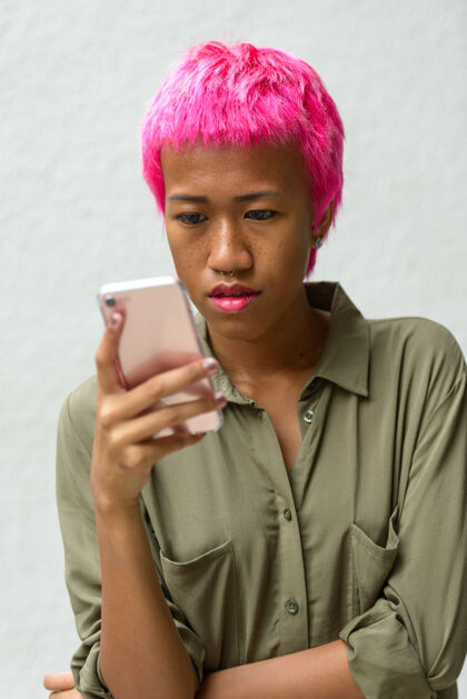 反叛年轻叛逆的亚洲女人的肖像 粉色的头发映衬着白色的空间古怪亚洲朋克