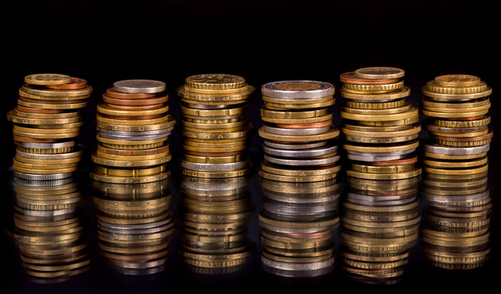 投资在黑色背景上堆叠不同国家的硬币财富储蓄珍贵