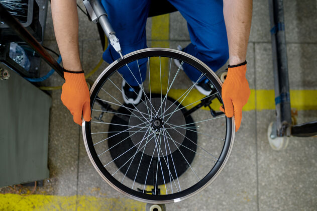 人工人用机床在工厂上安装新的自行车轮辋 顶部视图.自行车车轮装配车间 自行车配件安装运输铝车轮