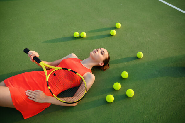 游戏疲惫的女子网球运动员拿着球拍躺在户外court.活动健康的生活方式 体育比赛 艰苦的球拍健身训练女人人站