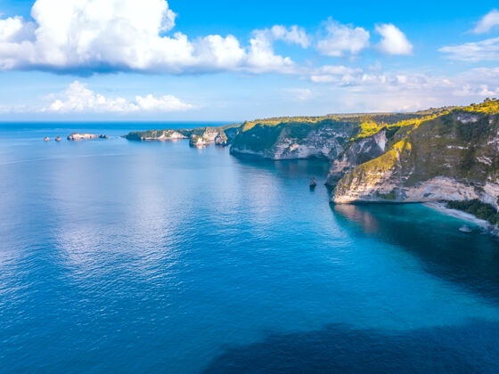 海浪印度尼西亚.penida岛阳光明媚沿海天气悬崖蓝色天空云.空中查看户外海岸岩石