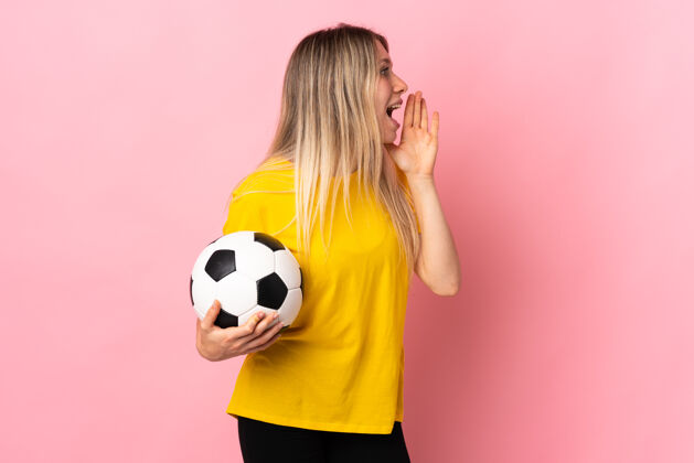 情绪一个年轻的足球运动员 一个被隔离在粉红色地板上的女人 张大嘴巴大喊大叫嘴成年人信息