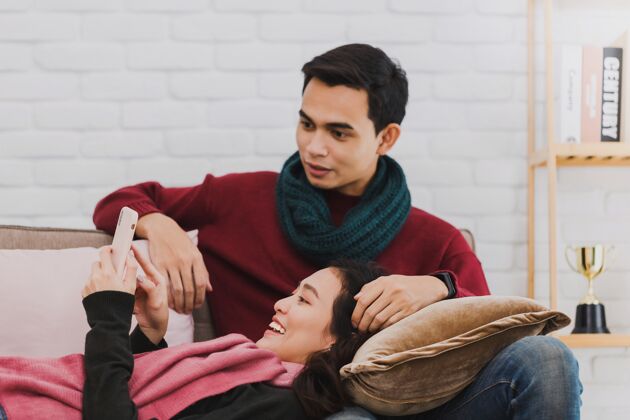 人年轻的亚洲情侣用信用卡和智能手机在线购物女性科技男人