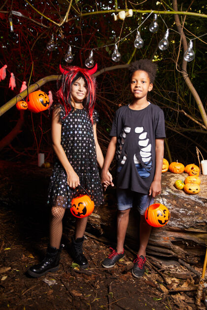 小学两个穿着盛装的朋友在黑暗中站在万圣节派对上手拉手的画像十月孩子不给糖就捣蛋