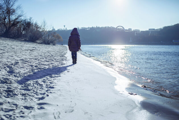 思想孩子们沿着河岸散步 享受冬日的阳光冬天孤独天气