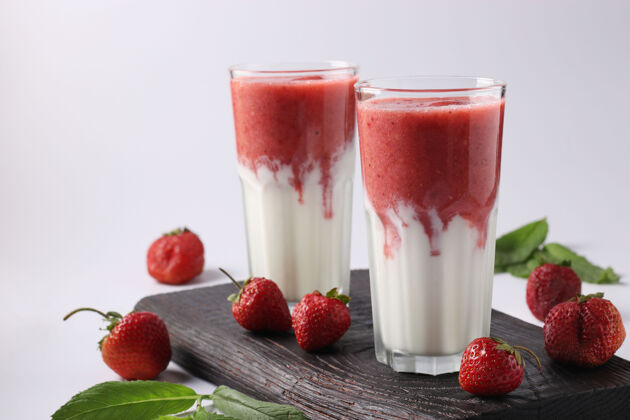分散两份自制冰沙 配新鲜草莓 薄荷和酸奶 白底杯装奶昔玻璃草莓