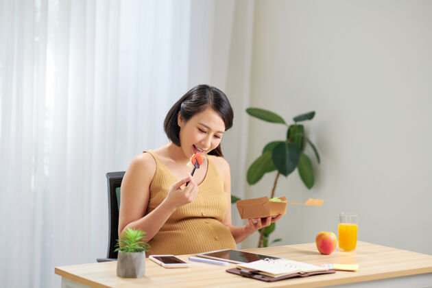 父母孕妇在家放松时健康吃沙拉和使用药片韩国人肚子中文