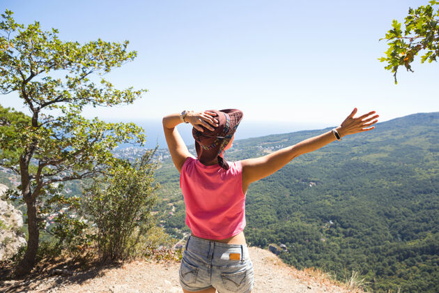 极限女游客举手眺望山顶全景 欢欣鼓舞 尽情享受自由与冒险享受顶端手