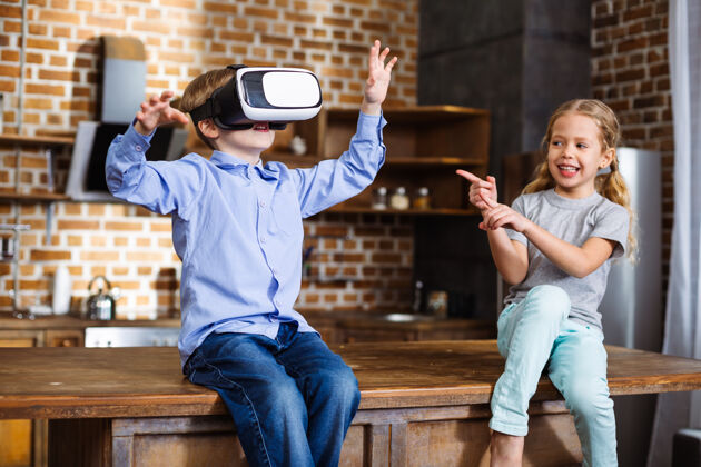 科技快乐的小男孩在测试虚拟现实设备 而他的妹妹在他身上束腰虚拟友谊休息