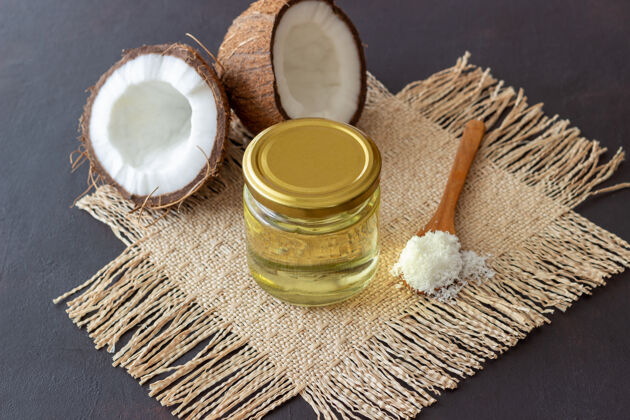 芳香把椰子油放在罐子里 新鲜椰子放在深色的表面天然化妆品油热带替代品